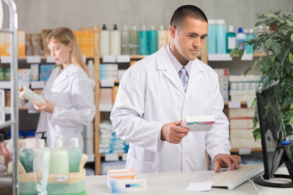 Male,Pharmacist,Holds,A,Package,Of,Pills,In,His,Hands