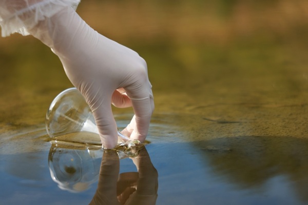 Examination,Of,Water,Quality.,Researcher,Taking,Water,Sample,From,Lake
