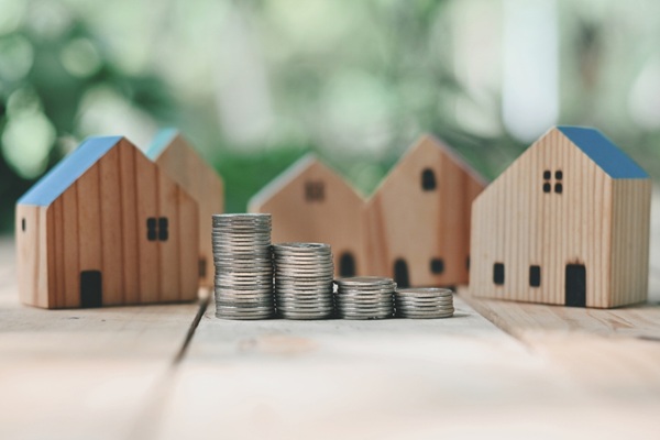Close,Up,Stack,Of,Coin,And,Toy,Wooden,House,On